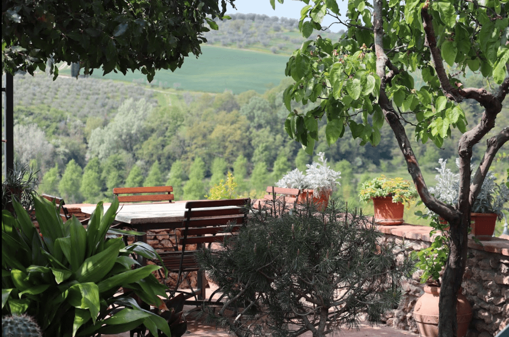 Patio of farmhouse and Tuscan countryside seen from Montalceto path in Crete Senesi region